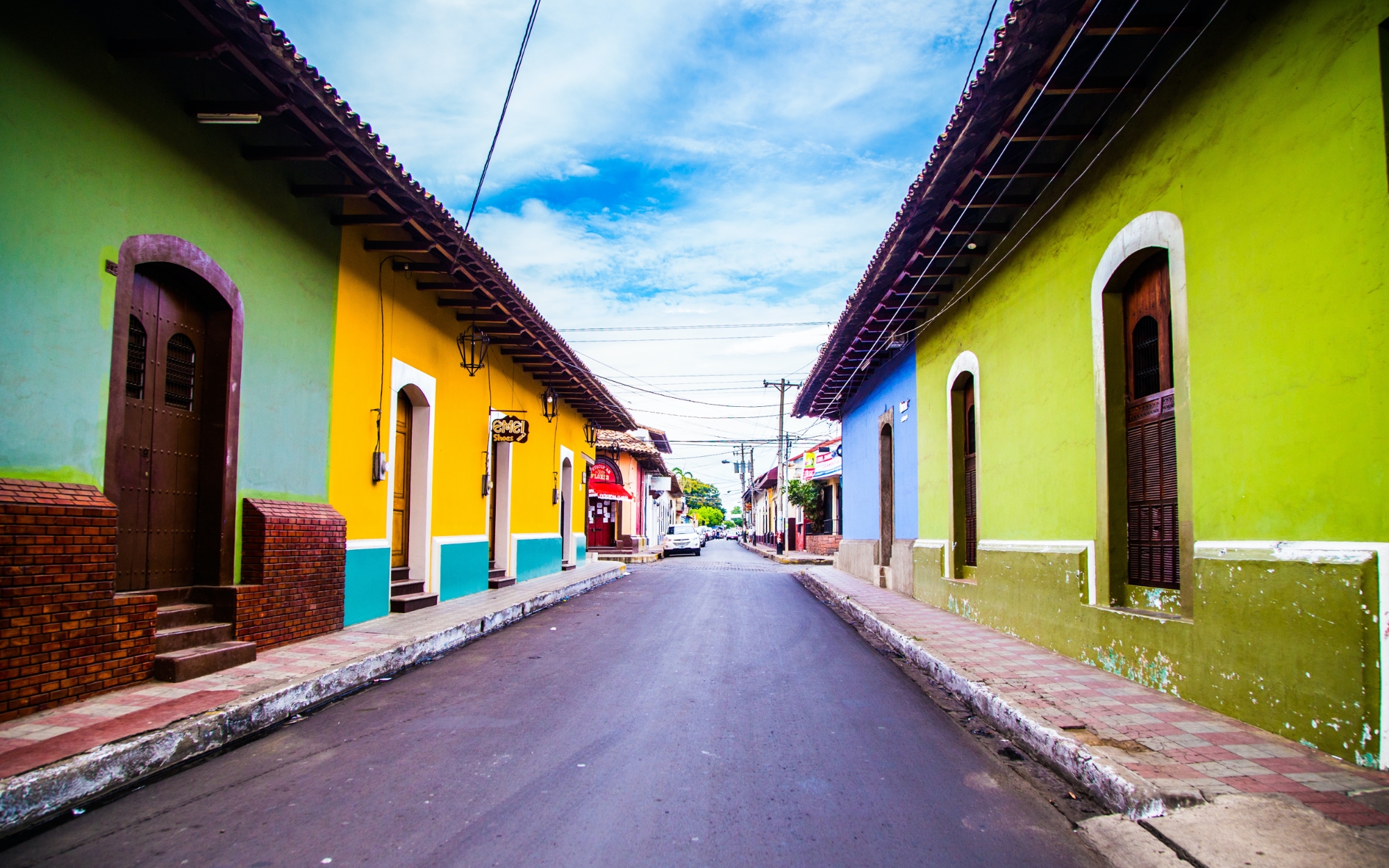 A narrow street in Nicaragua adorned with colorful buildings.