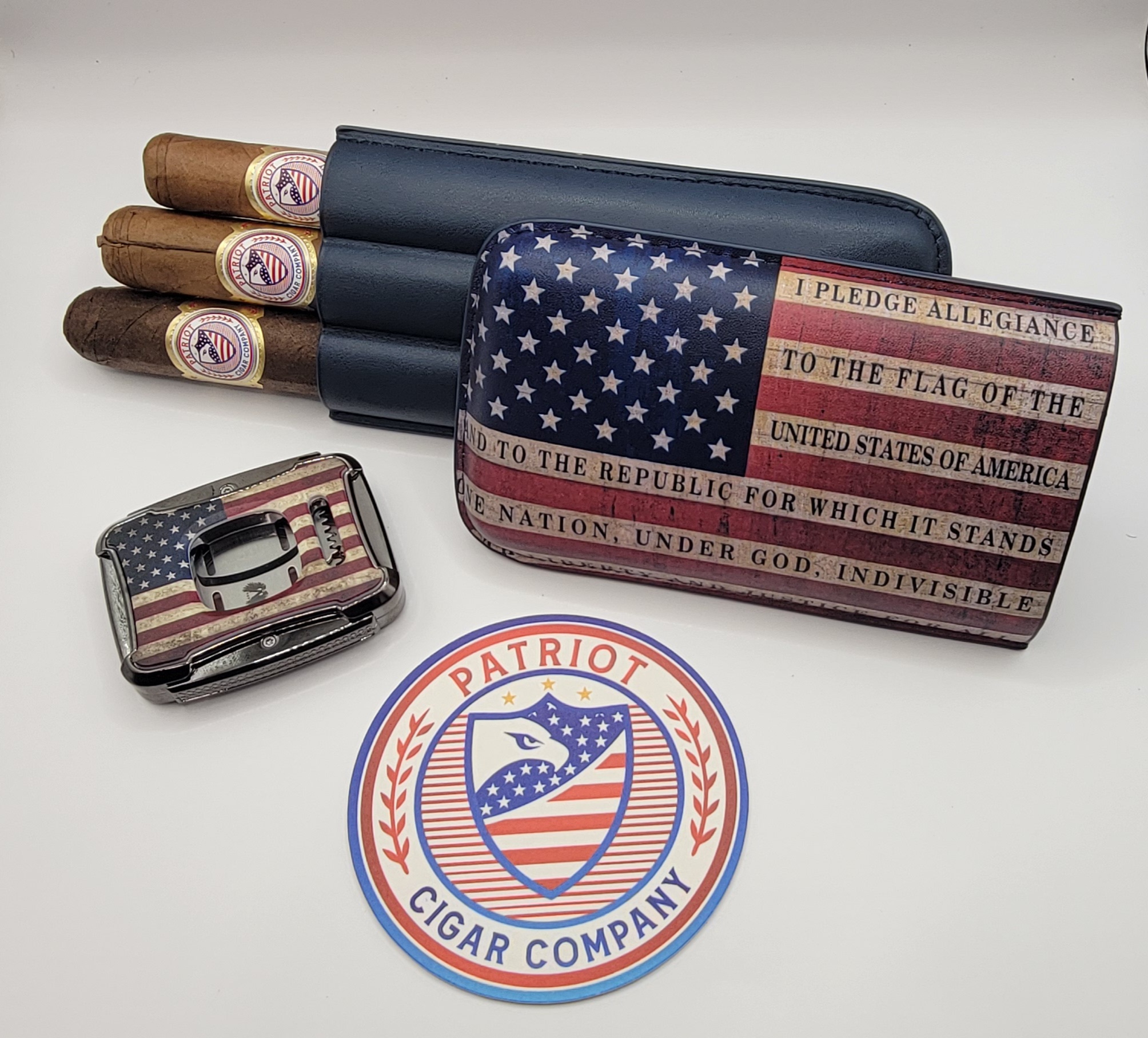 The PATRIOT PACK includes three cigars, a lighter, a cigar case, and a round sticker, all featuring American flag designs and "Patriot Cigar Company" branding, displayed on a white background.